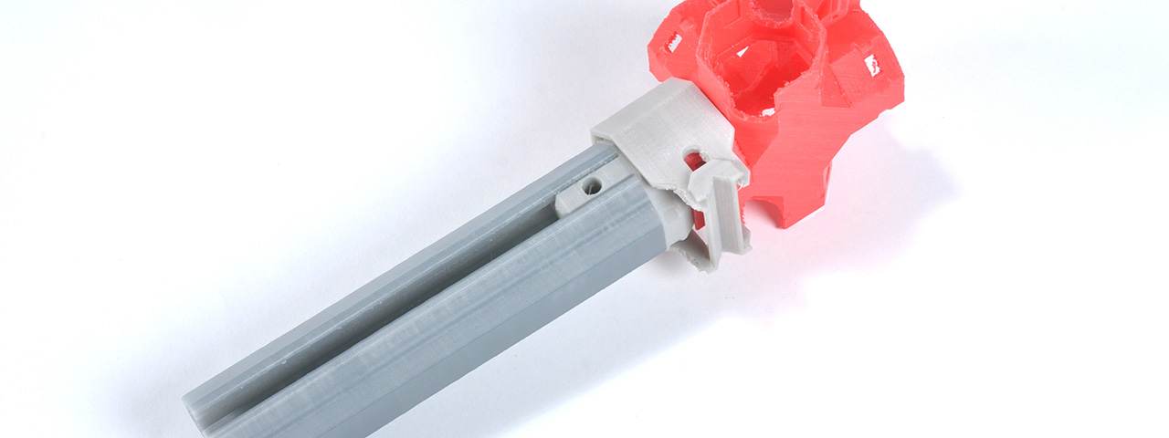 A gray MakeWiths extrusion clicked into a red 3D-printed corner joint